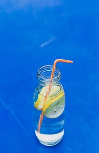 Close-up of drink on glass table against blue background