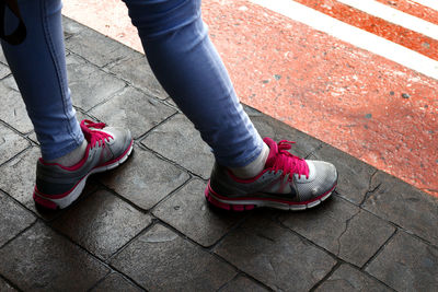 Low section of woman standing on footpath