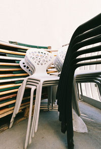 Close-up of chairs on table against white wall