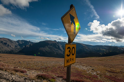 Information sign on landscape against mountain range