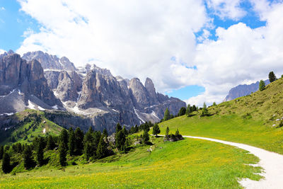 Scenic view of green landscape and mountains against sky