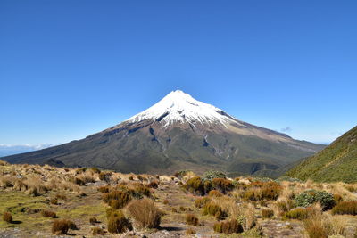 Scenic view of snowcapped mountains against clear blue sky