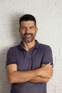 Portrait of smiling man standing against wall
