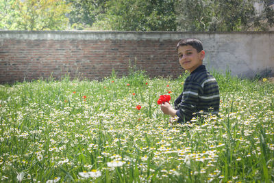 Portrait of boy with horse in grass