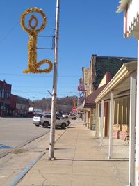 Street amidst buildings against clear blue sky