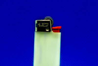 Close-up of telephone booth on table against blue wall