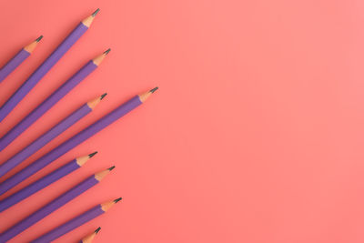 High angle view of pencils on peach background