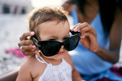 Mother and girl wearing sunglasses