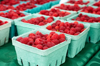 Fresh raspberries for sale on market stall