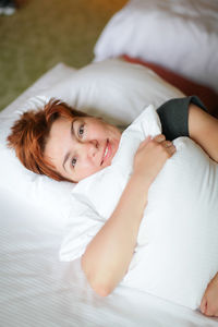 Portrait of woman lying on bed at home