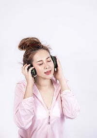 Young woman using smart phone against white background