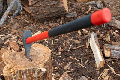 A view of a large cleaver, an axe with a plastic, rubber handle, which is stuck in a chock, a log