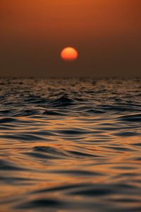 Scenic view of sea against orange sky