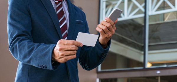 Midsection of businessman using mobile phone