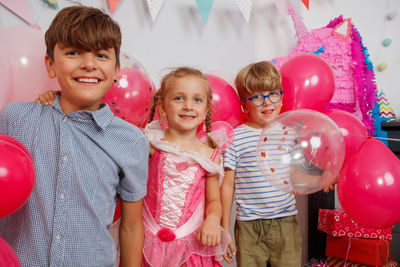 Portrait of smiling friends with balloons