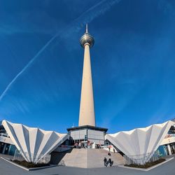 Low angle view of berliner fernsehturm against blue sky in city