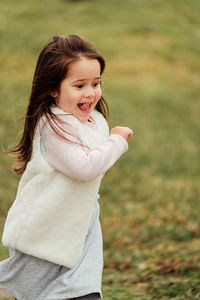 Girl looking away while standing outdoors