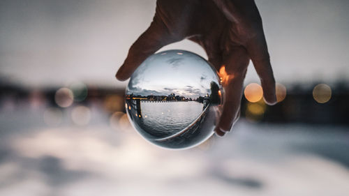 Holding a glassball hands, seeing berlin through the lens upside down