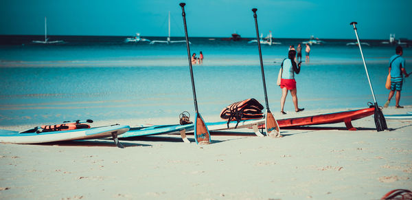 People at beach against sky