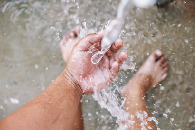 Midsection of man splashing water