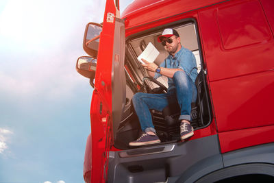 Low angle view of man holding steering wheel