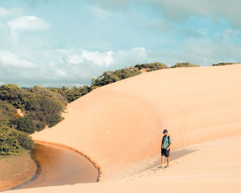 Tourist walking in the dunes of pirambu, sergipe