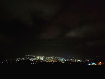 Illuminated cityscape against sky at night