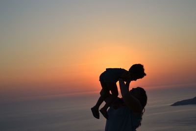 Silhouette of mother with child at beach