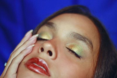 Close-up of teenage girl with make-up sleeping on bed