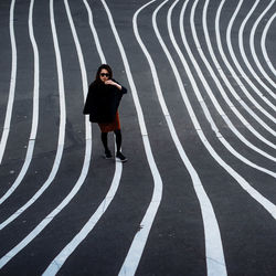 Full length of woman standing on striped street