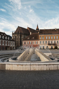 Buildings against fountain in city