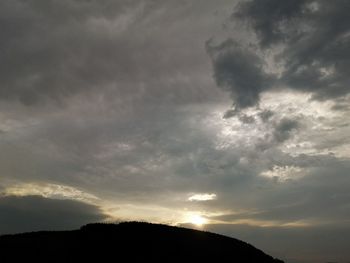 Low angle view of silhouette mountain against sky at sunset