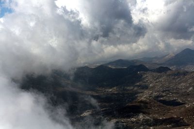 Scenic view of mountains against cloudy sky