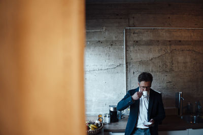 Mature businessman drinking coffee in office cafeteria