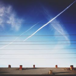 Low angle view of power line against blue sky