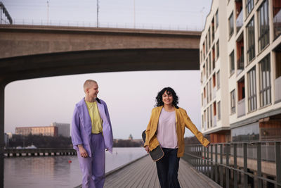 Happy young women walking together at river