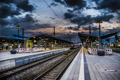 Railroad station against dramatic sky