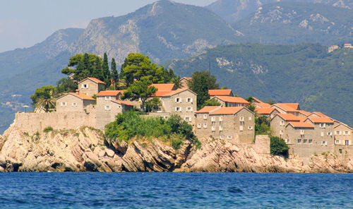 Houses by sea against mountains