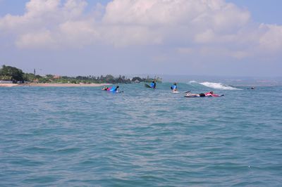 People on sea against sky