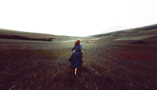 Rear view of woman walking on landscape
