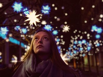 Close-up of teenage girl looking at illuminated christmas lights