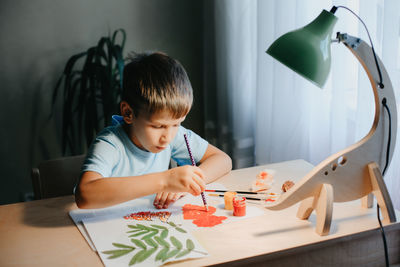 Boy drawing on book at home