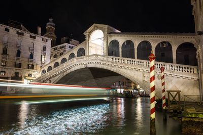 Arch bridge over river at night