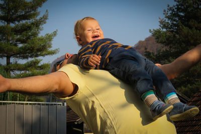 Smiling cute baby boy enjoying while relaxing on chest of father