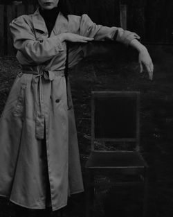 Midsection of woman standing by wall outdoors