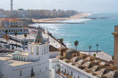 High angle view of townscape by sea against sky