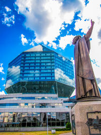 Low angle view of modern building against cloudy sky