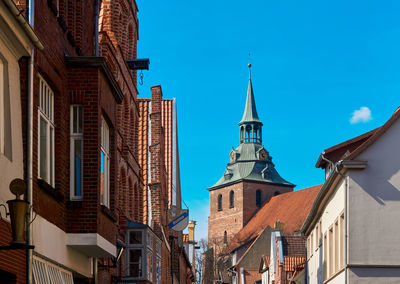 Lueneburg, germany, april 8., 2020,church tower behind historical brick buildings 