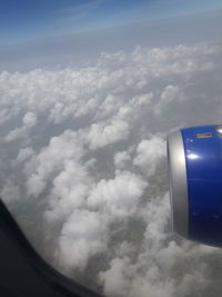 Close-up of airplane wing against cloudy sky