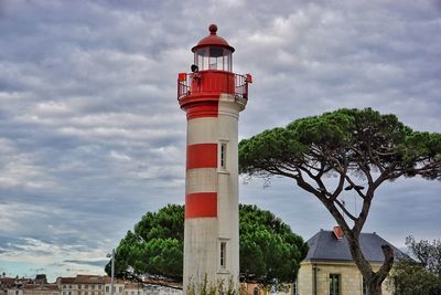 Lighthouse by sea against sky